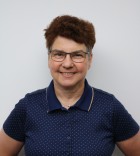 Juliane Neuß trägt eine Brille und ein Blaues Hemd mit kurzen Haaren, das Foto stammt von 2021 und zeigt die ca. Anfang 60 Jahre alt